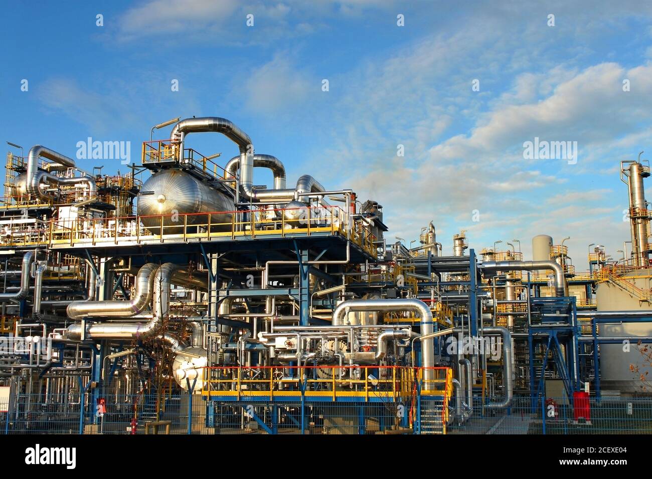 Impianto petrolchimico, fabbrica di raffineria petrolifera su cielo blu. Foto Stock