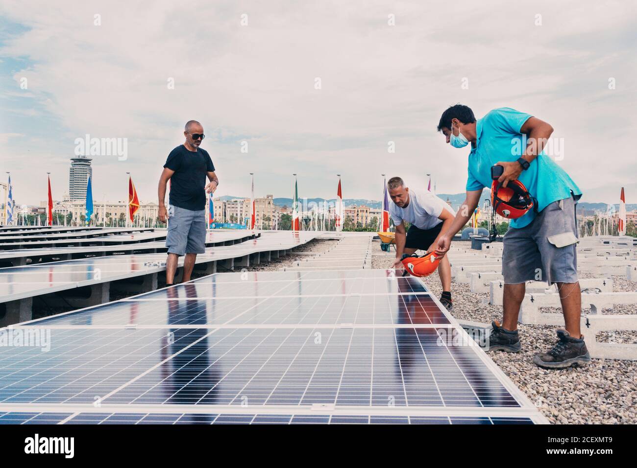 Gruppo di ingegneri maschi che installano moderne batterie solari in ambito industriale impianto di impianti moderni Foto Stock