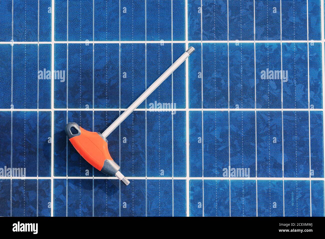 Cacciavite posizionato sulla parte superiore della batteria solare contemporanea in fabbrica Foto Stock