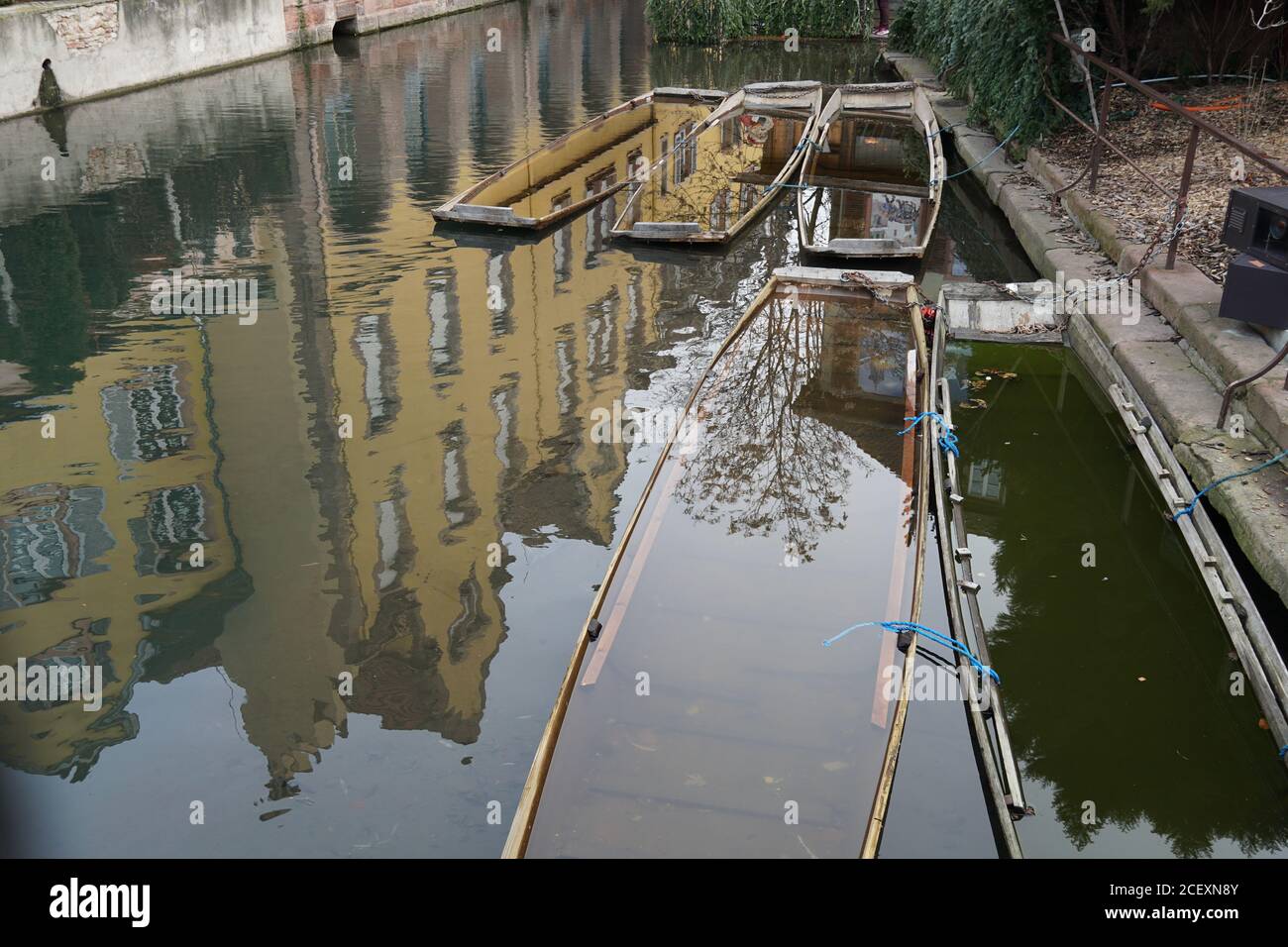 Barche ormeggiate allagate a piccola Venezia, Colmar, Francia. Le facciate degli edifici che confinano con le rive del canale si specchiano nell'acqua. Foto Stock