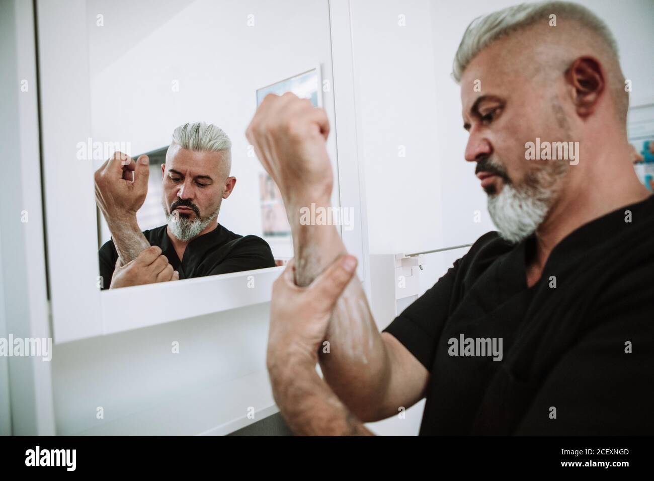 uomo in piedi in bagno e lavarsi le mani con acqua e sapone Foto Stock