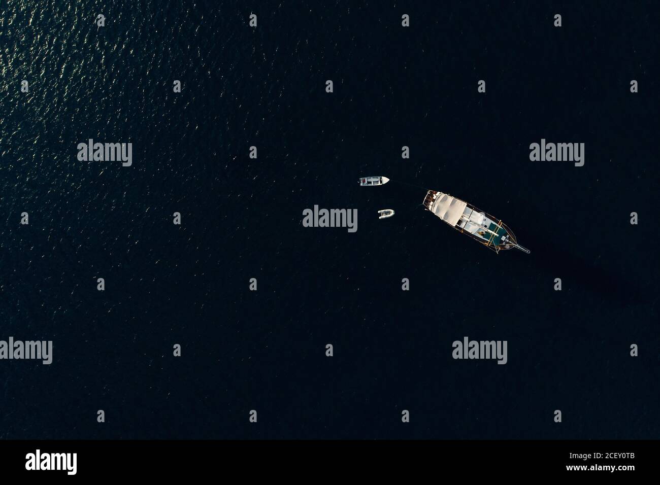 Dall'alto di varie barche a motore moderne che galleggiano sulla calma superficie del mare durante la giornata di sole Foto Stock