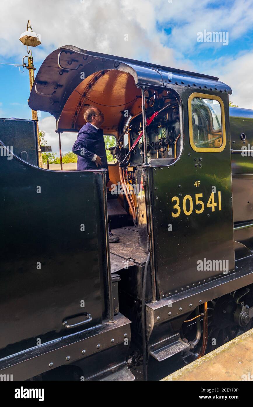 Autista del treno che prepara la locomotiva a vapore nero Rocket per la partenza sulla linea ferroviaria Bluebell Heritage, Sheffield Park, East Sussex, Inghilterra, Regno Unito Foto Stock
