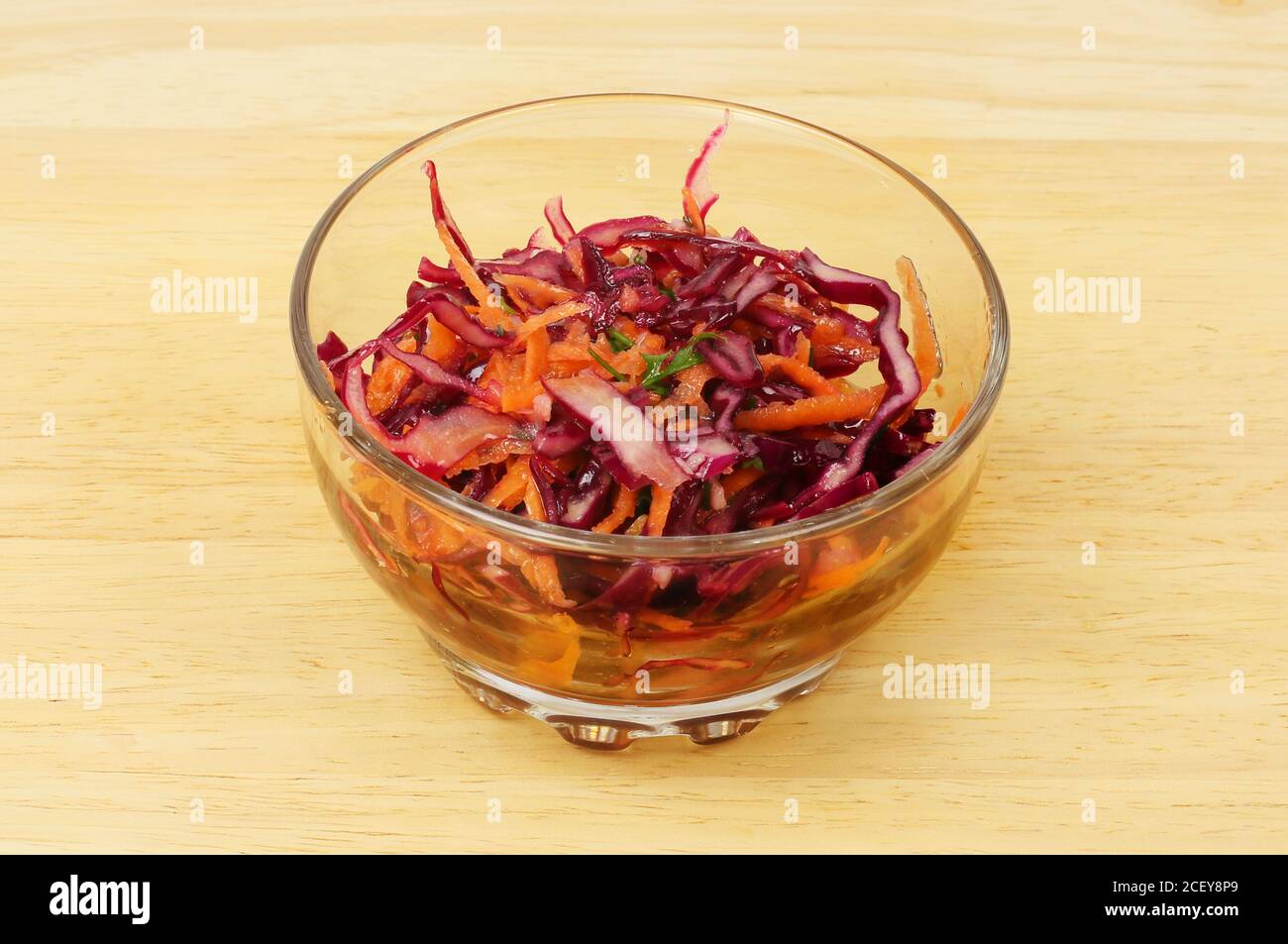 Cavolo rosso e insalata di carote in un recipiente di vetro un piano in legno Foto Stock