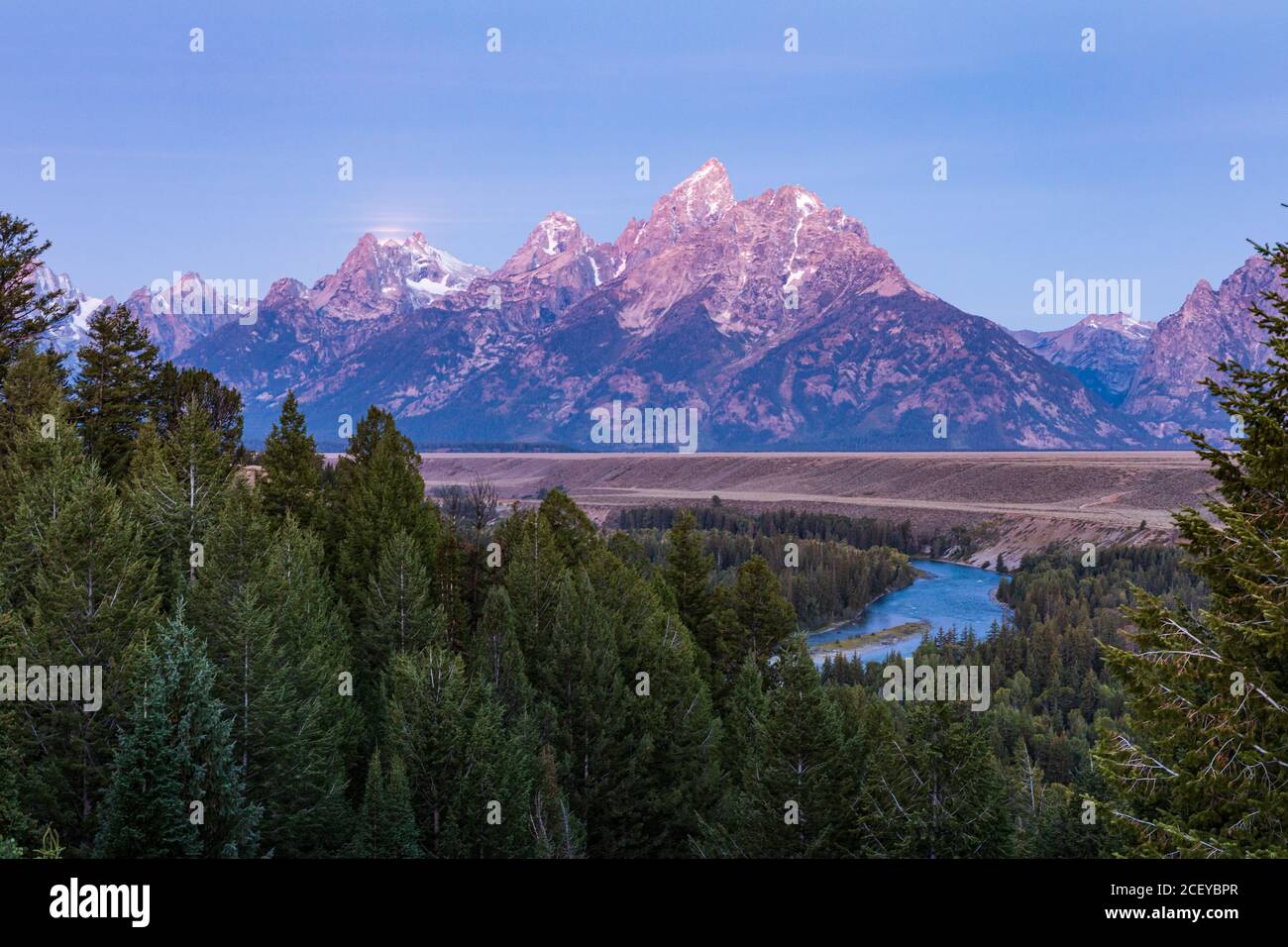 Luce rosa di alba splende sulle montagne Teton e. Il fiume Snake visto dal fiume Snake si affaccia Nel Parco Nazionale di Grand Teton Foto Stock