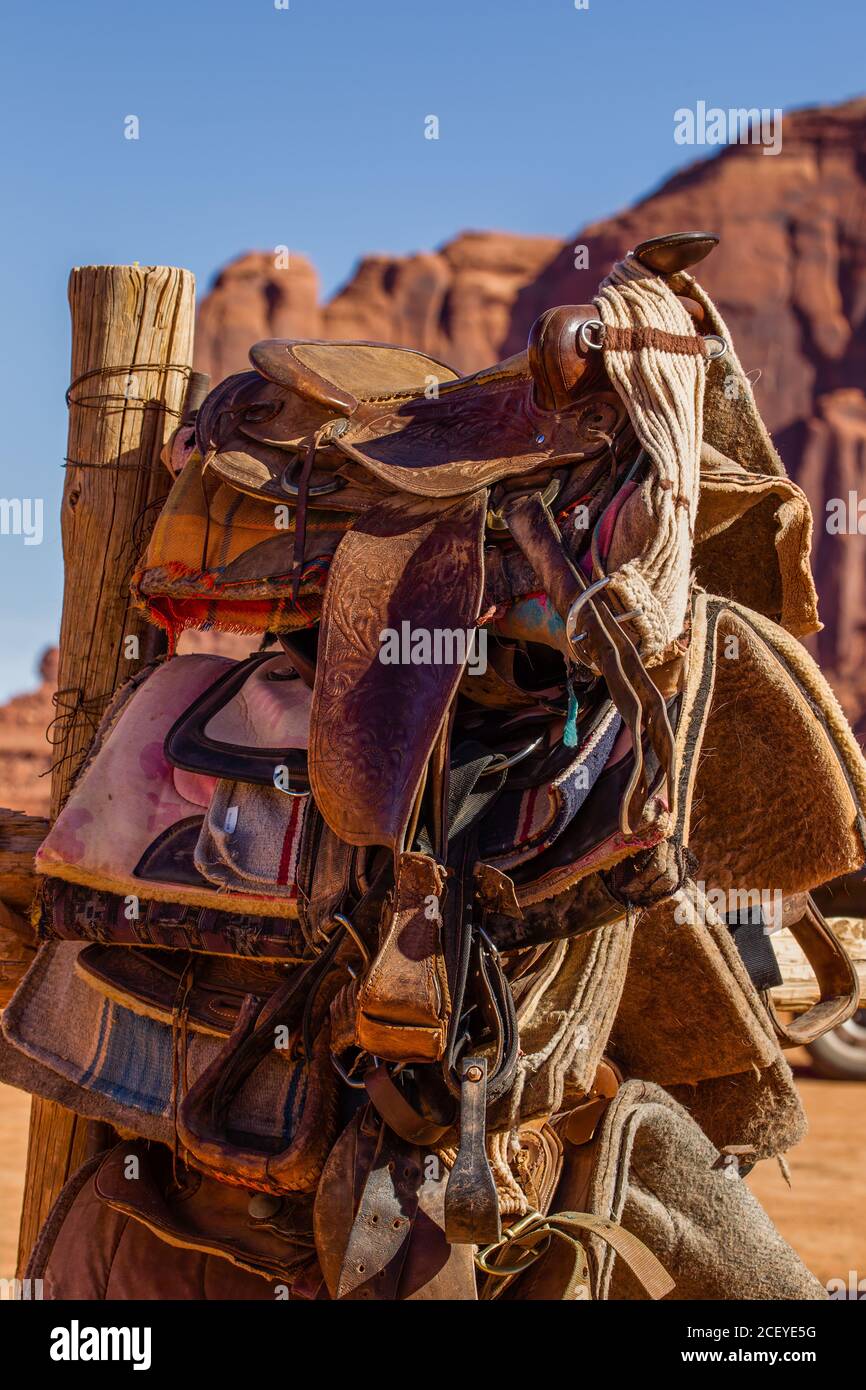 Una pila di selle in stile occidentale per cavalcare i cavalli nel Monument Valley Navajo Tribal Park, nel nord dell'Arizona. Foto Stock