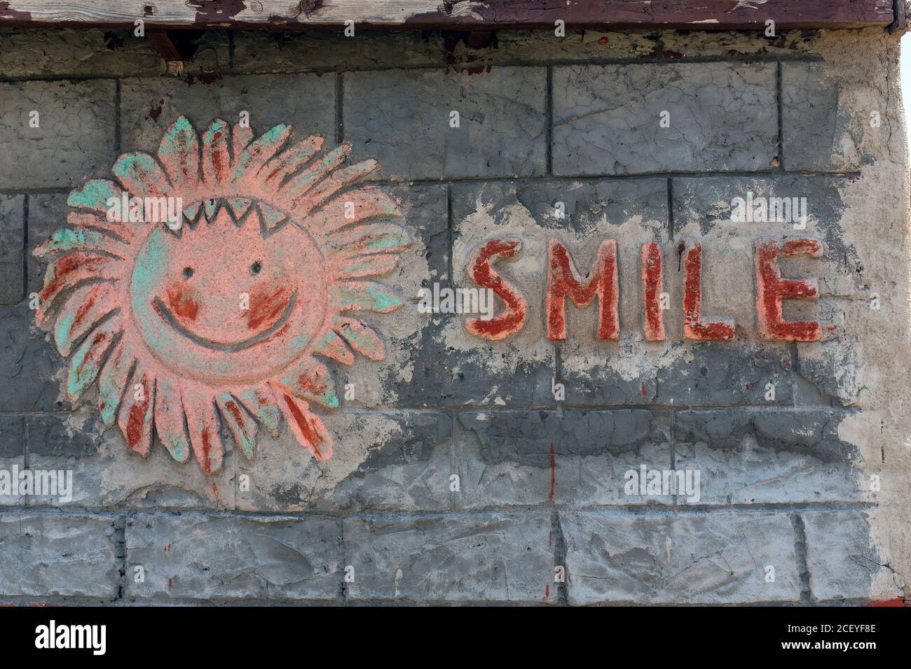'sorriso' e sole faccia in cemento sulla parete del garage Foto Stock