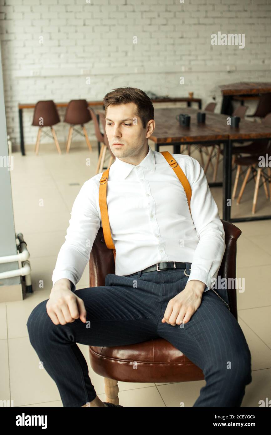 uomo d'affari caucasico di buon aspetto che indossa elegante abito formale  sedersi sulla sedia nel proprio ufficio, uomo fiducioso guardare lato.  successo, business c Foto stock - Alamy