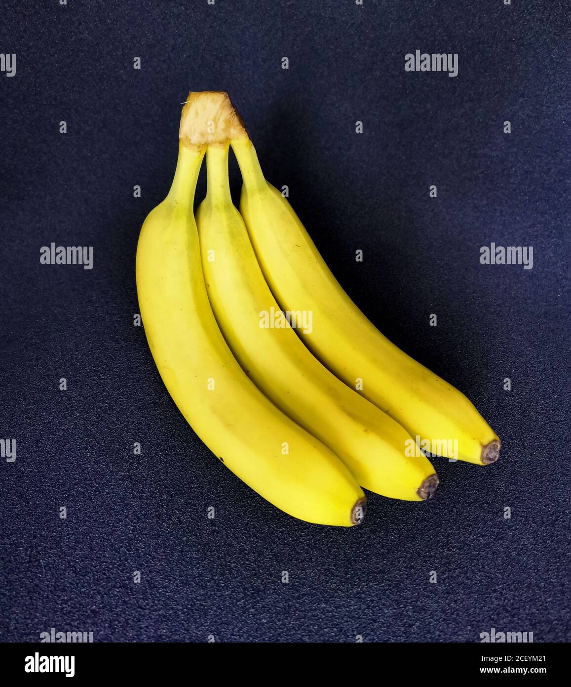 Tre banane mature su sfondo scuro Foto Stock