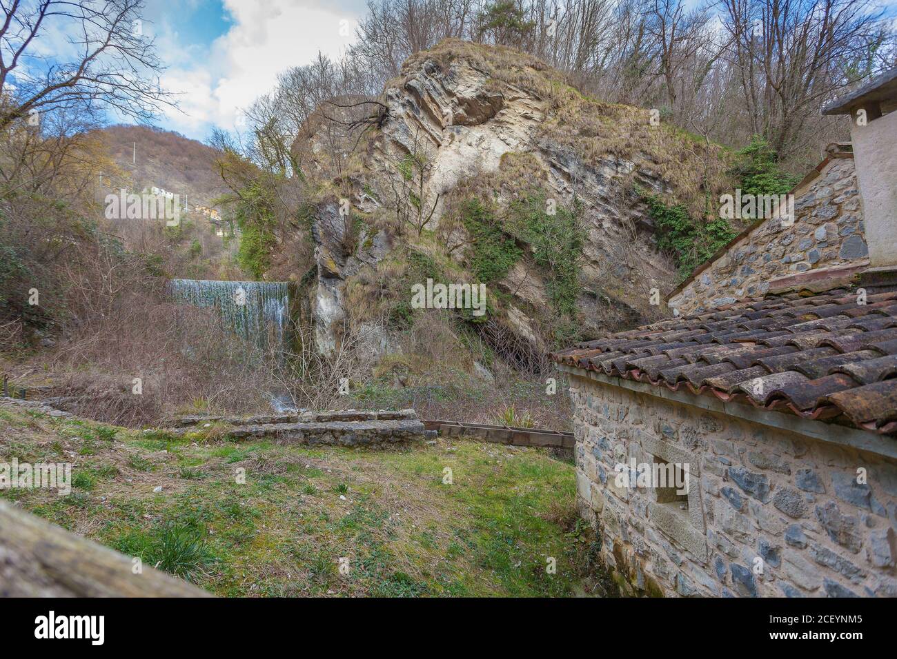 Cascata in una valle con una casa antica Foto Stock