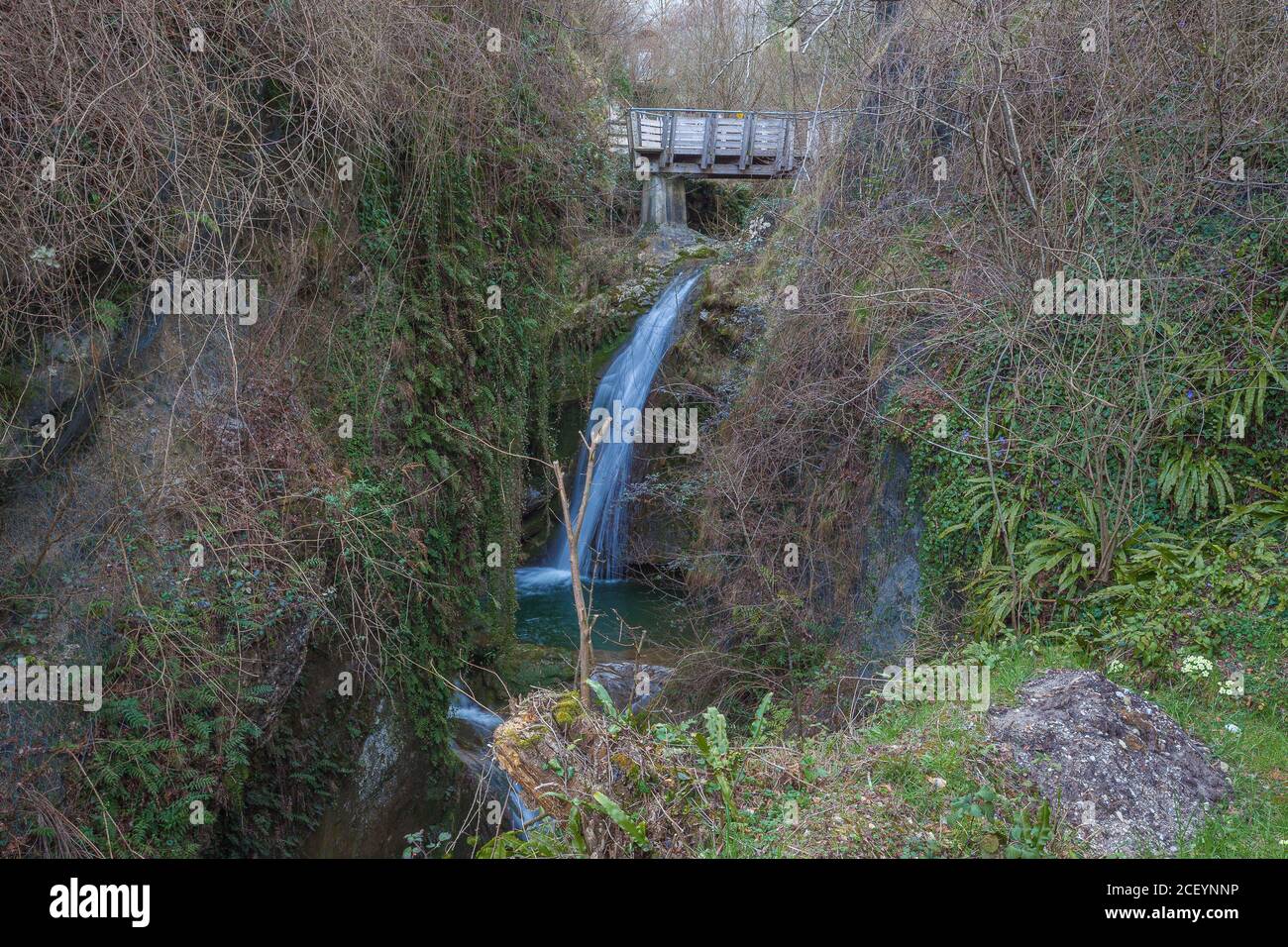 Ponte di legno sulla cascata in una valle Foto Stock