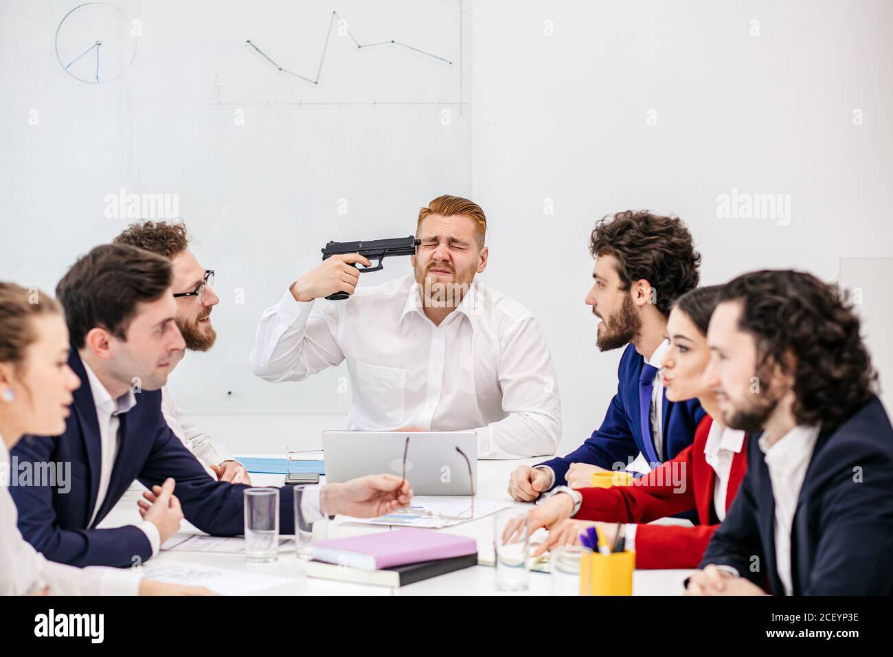gruppo di giovani uomini d'affari caucasici in carica, giovani uomini d'affari che guardano depressi e preoccupati di lavorare in una meetina, tenendo in mano la pistola, Foto Stock