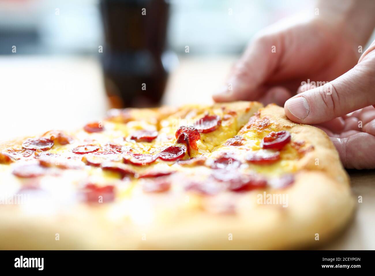 Braccio maschile prendendo fetta di gustosa pizza fresca Foto Stock