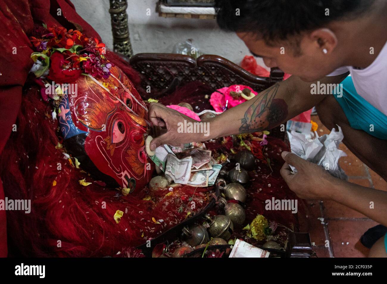 Un devoto Laxman ranjit adora una maschera del Lakhey, il protettore della Dea Kumari, durante il festival Indra Jatra.Indra Jatra, la festa di Rein di Dio è celebrata con molto fanfare nella valle di Kathmandu. In questo festival di otto giorni, i carri della dea vivente Kumari e degli dei viventi Ganesh e Bhairab sono tirati in varie parti della città, ma a causa della pandemia di Covid-19 per la prima volta nella storia la lavorazione dei carri è stata annullata. Il pulu kisi e il lakhey erano adorati alle loro case. Foto Stock