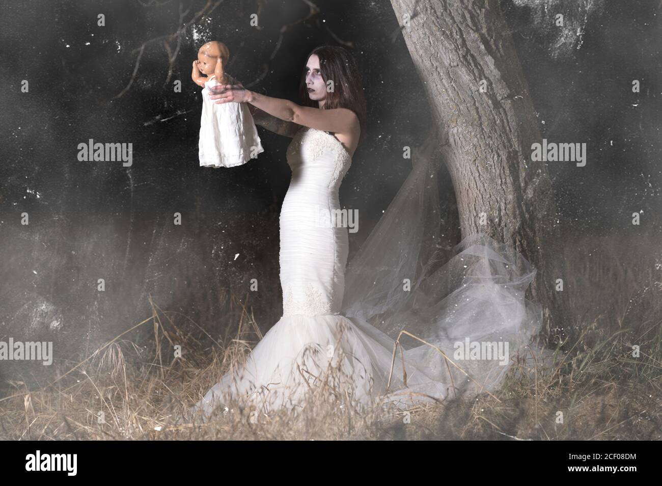 Orrore scena di una donna posseduta tenendo una bambola. Foto di alta qualità Foto Stock