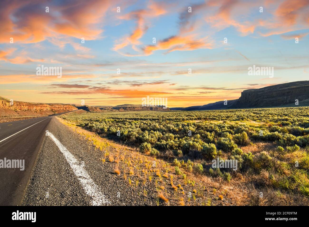 Lunga strada avvolgimento se il deserto piano terra spazzola nelle montagne dell'entroterra a nord-ovest di rurale dello stato di Washington nel deserto americano Foto Stock