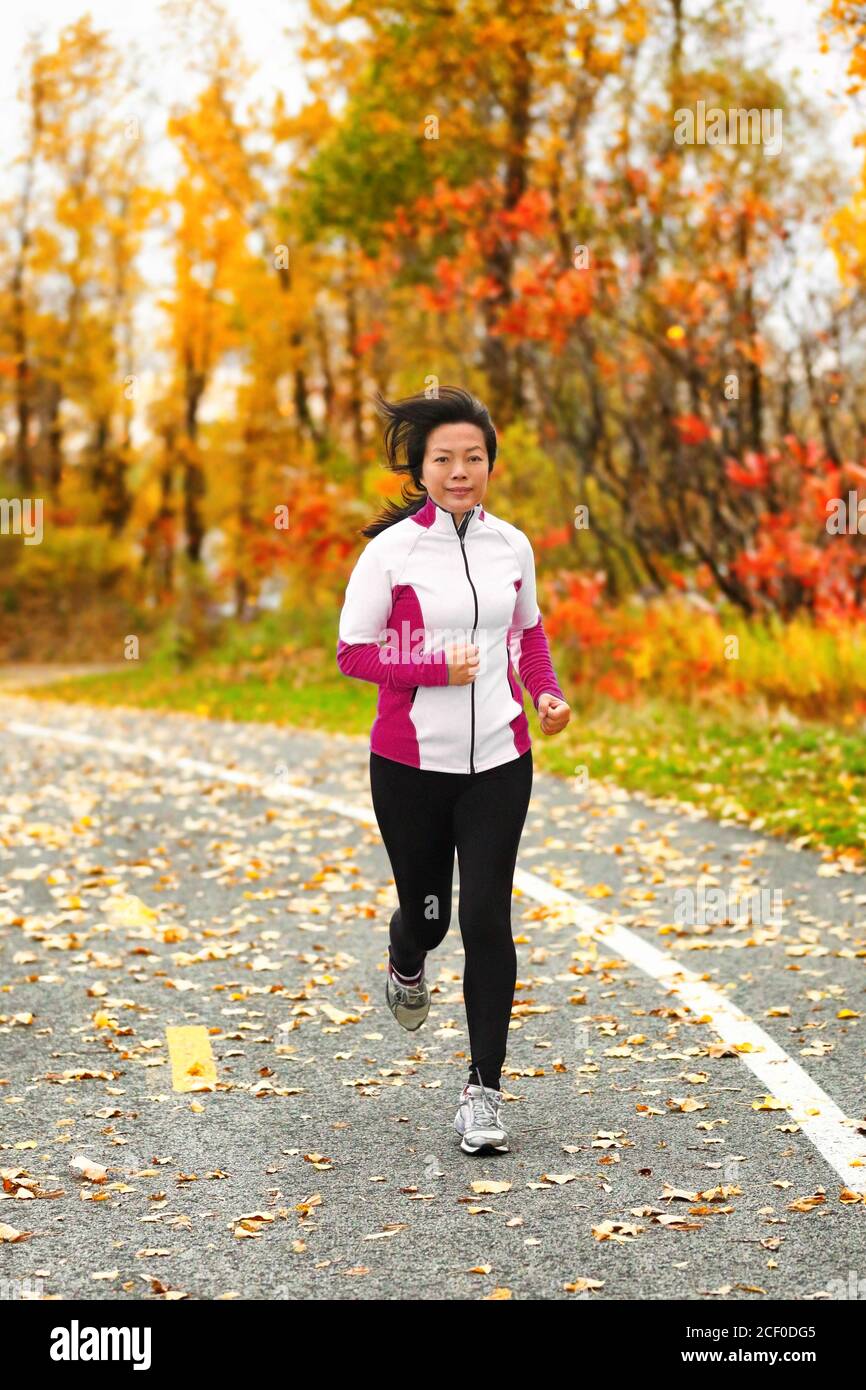 Media età matura sana donna asiatica correre jogging Foto Stock
