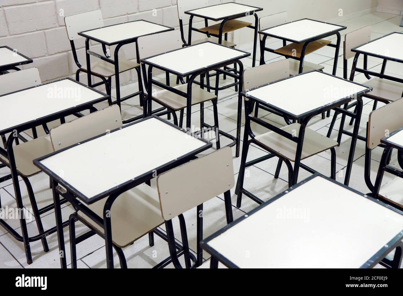 diversi tavoli e sedie in classe in un vuoto scuola senza studenti Foto Stock