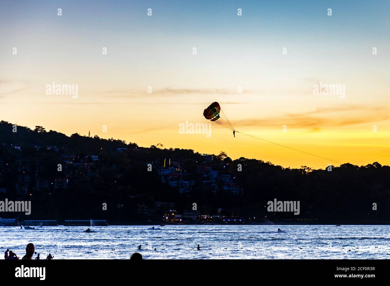 Parapendio sul Mare delle Andamane al tramonto, Patong, Phuket, Thailandia Foto Stock