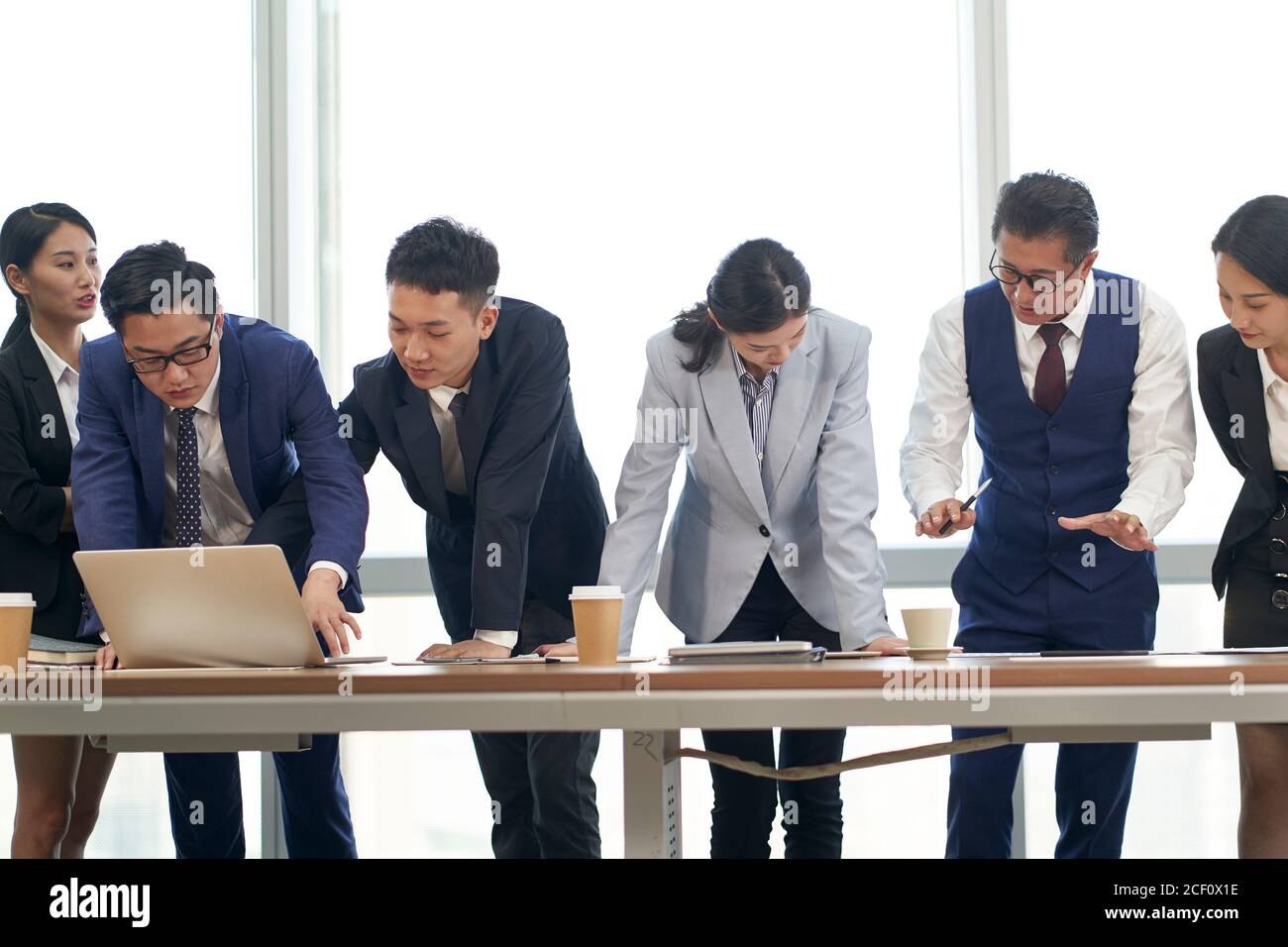 gruppo di dirigenti aziendali asiatici che si incontrano in ufficio per analizzare prestazioni aziendali Foto Stock