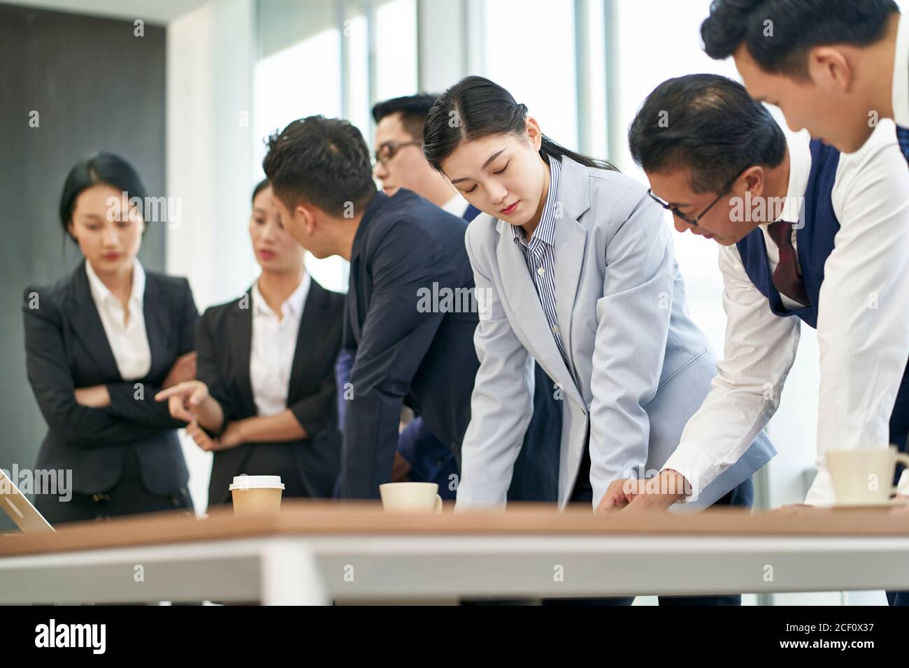 gruppo di dirigenti aziendali asiatici che si riunono in carica per discutere prestazioni aziendali Foto Stock
