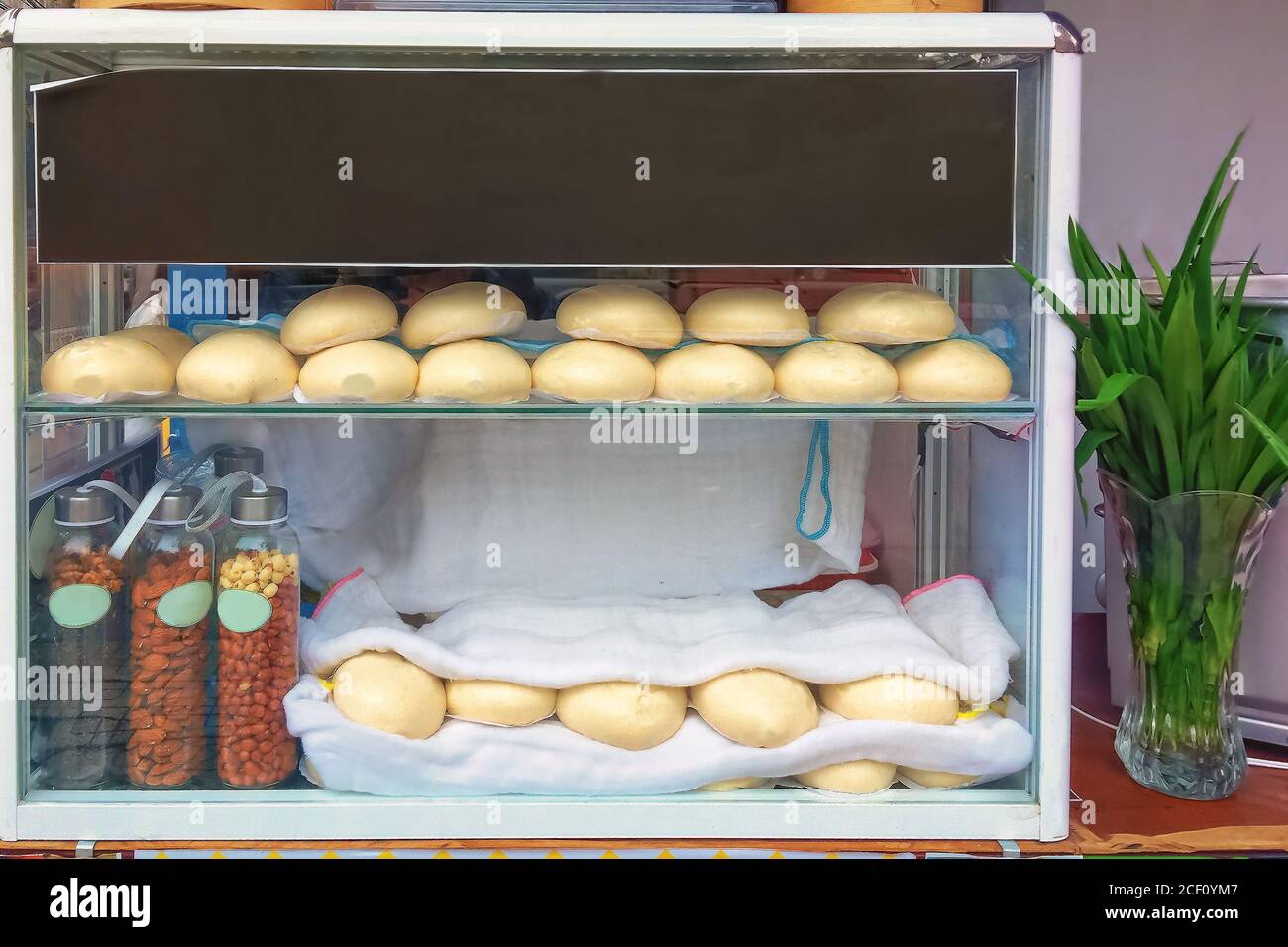 Gnocchi tradizionali vietnamiti al vapore Banh Bao Tuoi su un distributore automatico. Cibo di strada asiatico Foto Stock