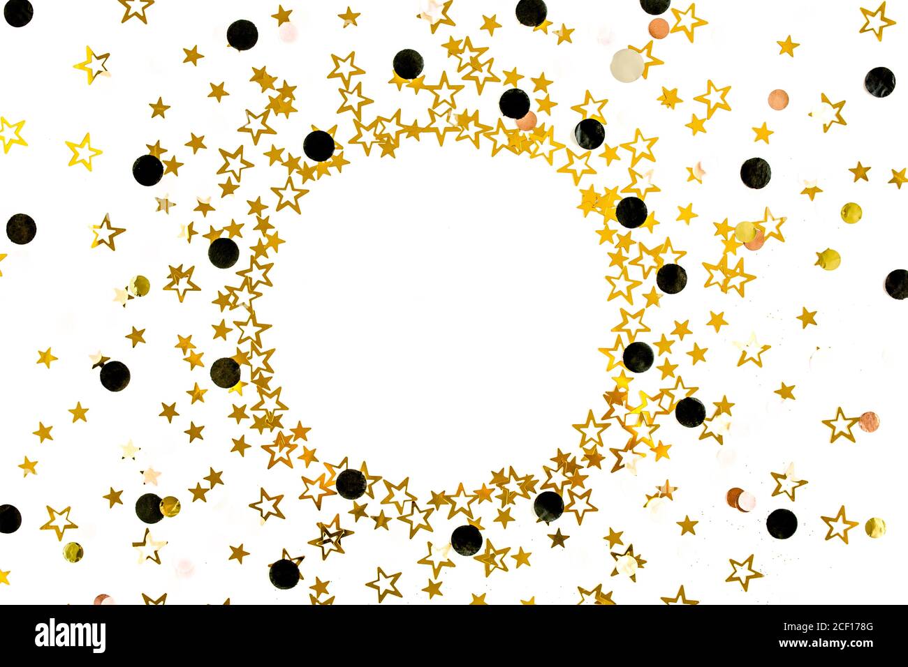 Le stelle d'oro confetti su sfondo bianco e festoso. Celebrazione colorata, sfondo di compleanno. Modello di Natale o Capodanno. Disposizione piatta, vista dall'alto Foto Stock