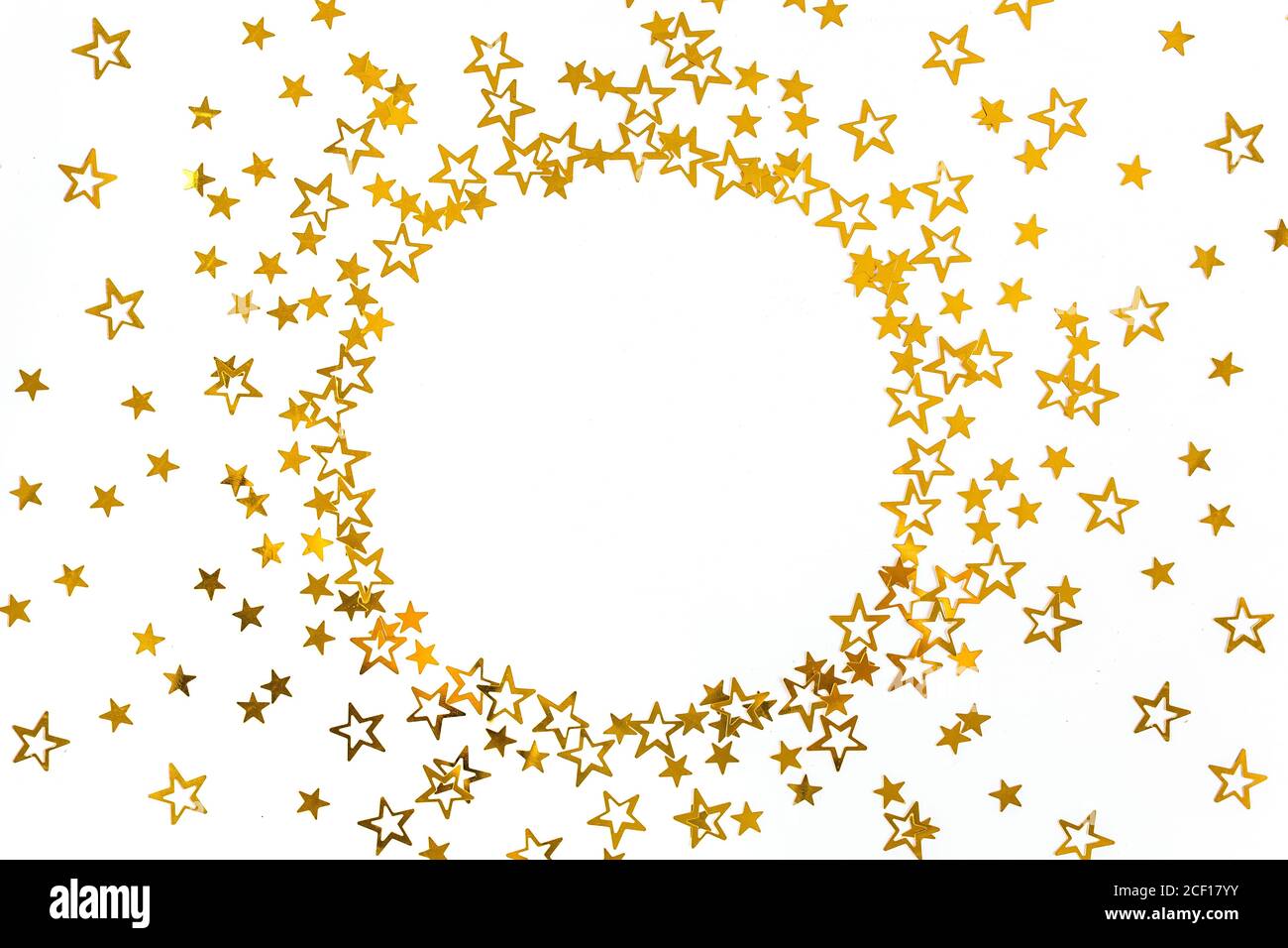 Cornice rotonda con stelle d'oro confetti, decorazione con glitter su sfondo bianco e festoso. Modello di Natale o Capodanno. Disposizione piatta, vista dall'alto Foto Stock