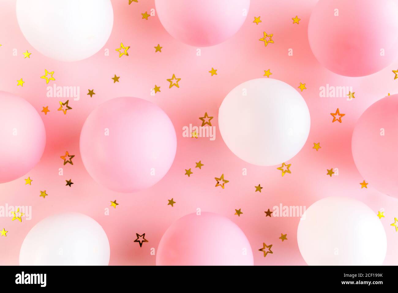 Palloncini e confetti su sfondo rosa. Giorno di San Valentino, compleanno, concetto di vacanza. Disposizione piatta, vista dall'alto Foto Stock