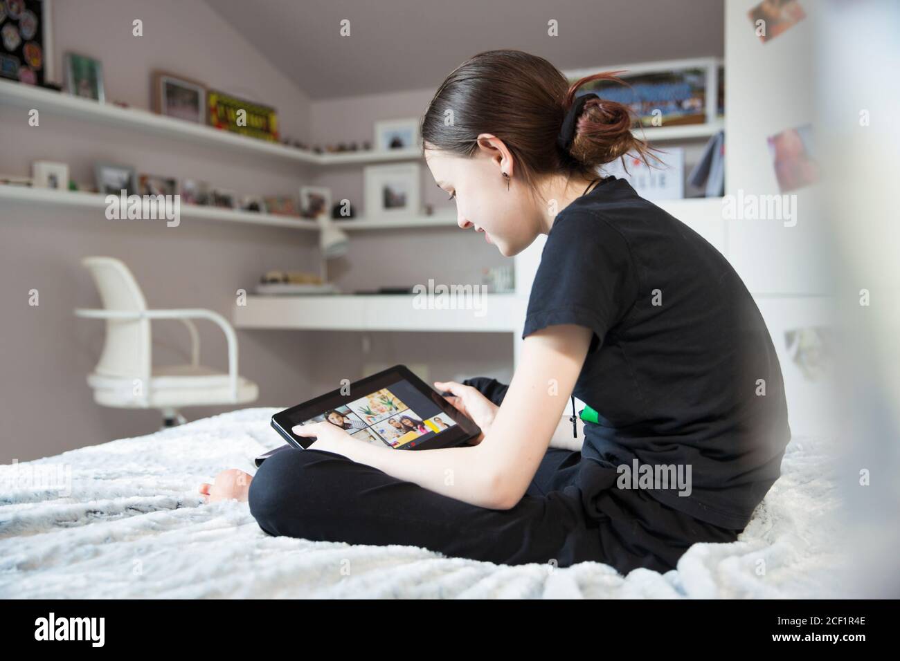Ragazza e-learning con tablet digitale a letto Foto Stock