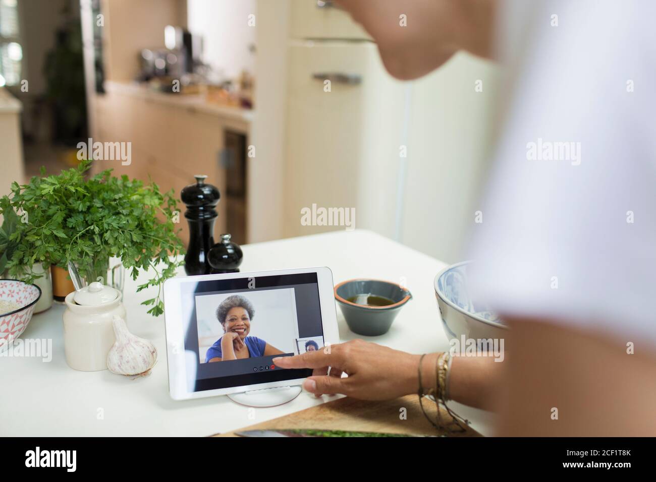 Donna che parla con gli amici sullo schermo del tablet digitale cucina Foto Stock