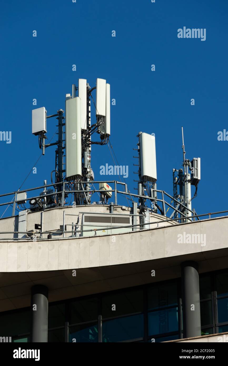 Antenne per telefoni cellulari 5G e 4G installate sul tetto di un edificio.  Cielo blu Foto stock - Alamy