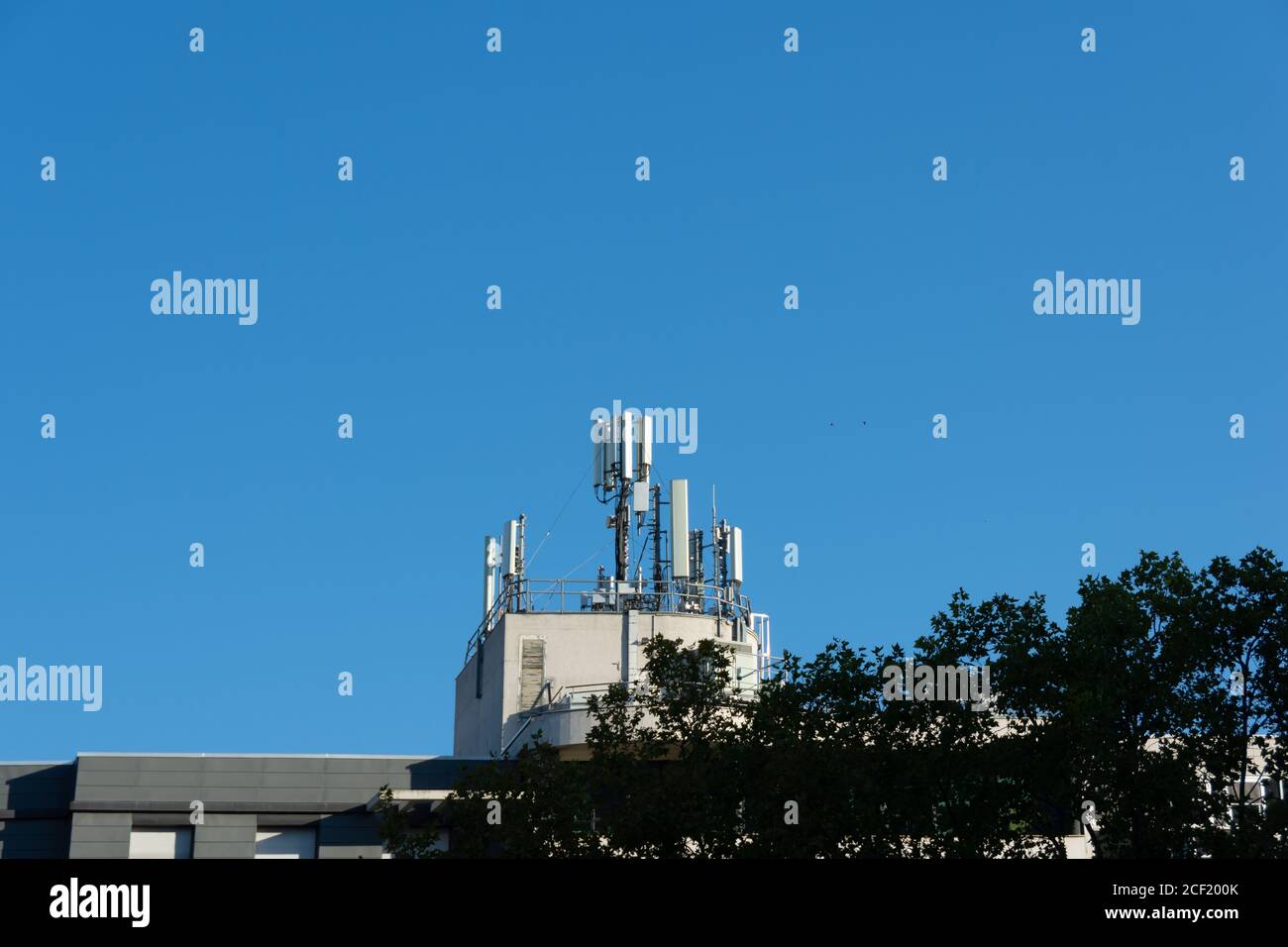 Antenne per telefoni cellulari 5G e 4G installate sul tetto di un edificio. Cielo blu. Spazio di copia per il testo Foto Stock