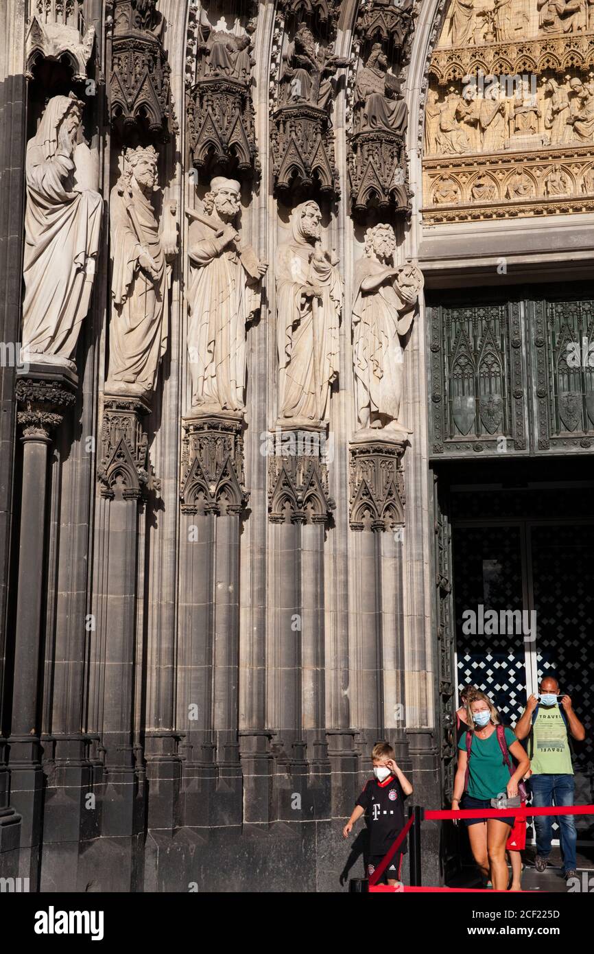 Durante la pandemia della corona, visitatori con maschere che lasciano la cattedrale, Colonia, Germania. Waehrend der Coronapandemie kommen Besucher mit Masken aus d Foto Stock