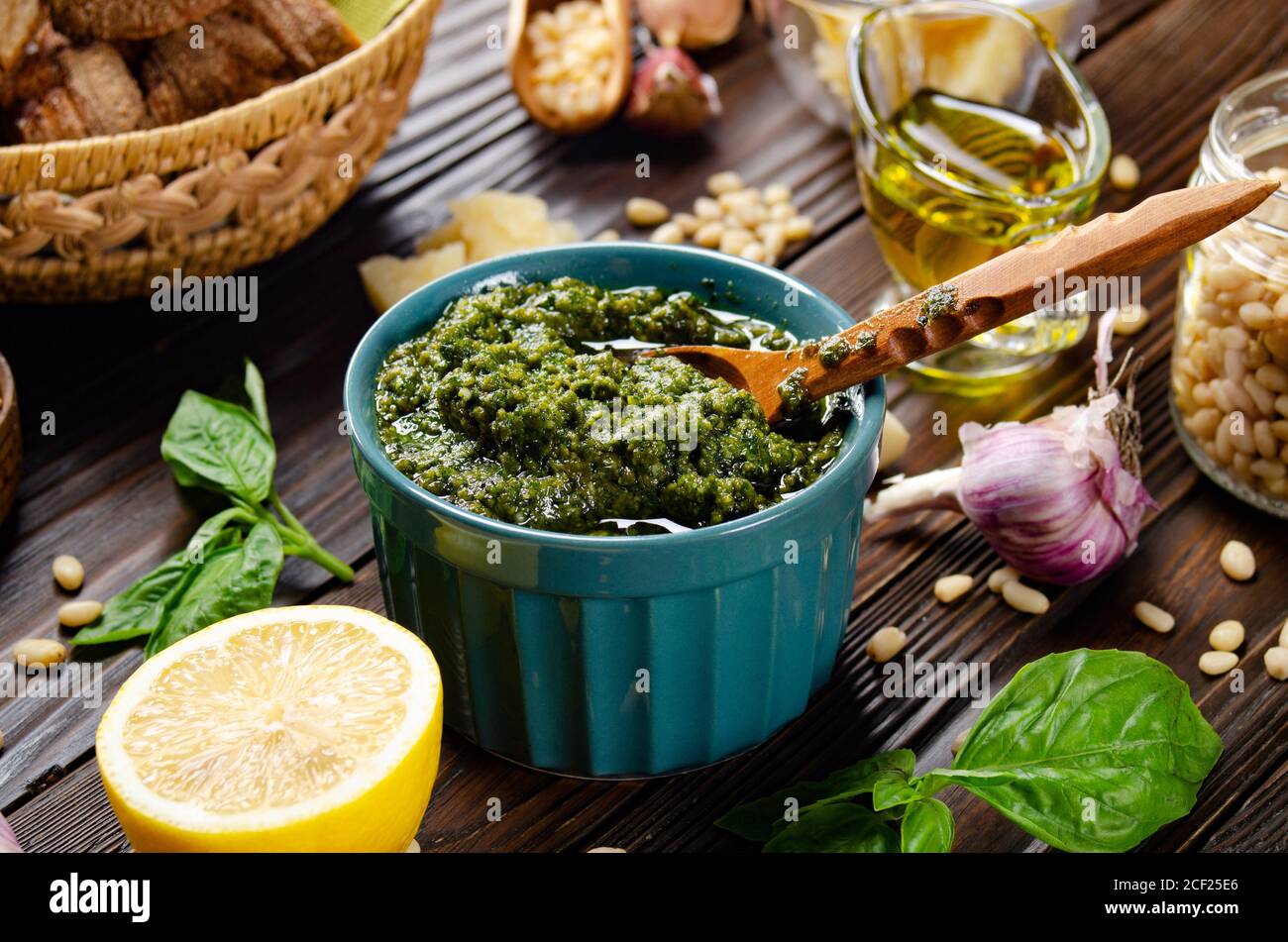 Fondo alimentare di pesto genovese e i suoi ingredienti che rappresentano la cucina mediterranea. Foto Stock