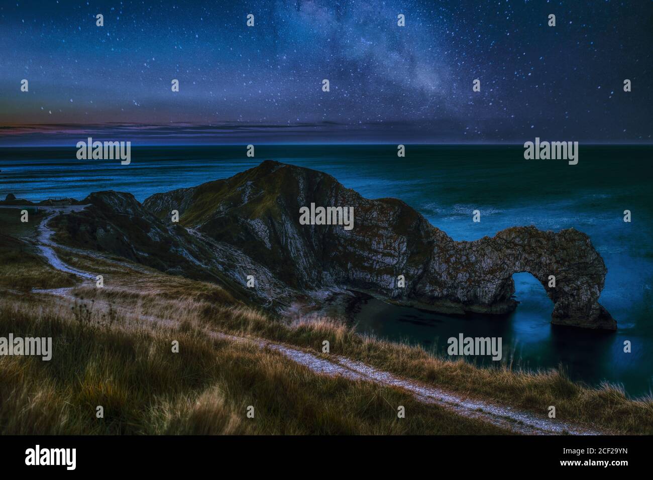 Night Sky Landscape con Milky Way Galaxy sopra il famoso Luogo da visitare e viaggiare Durdle Door English Beach on La costa jurassica del Dorset Foto Stock
