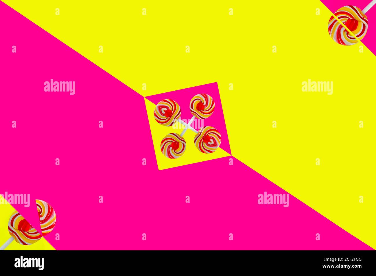 Lollipop colorati su triangoli gialli e rosa Foto Stock