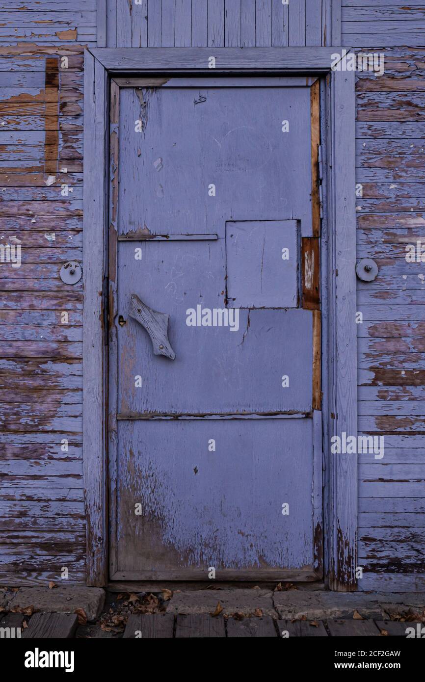 vecchio porta chiusa in legno d'epoca, viola con vernice da peeling Foto Stock
