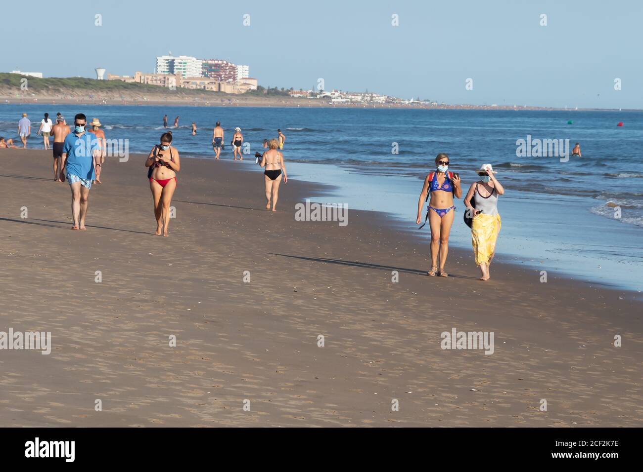 Punta Umbria, Huelva, Spagna - 31 agosto 2020: Persone che camminano in spiaggia indossando maschere protettive o mediche. Nuova normalità in Spagna con d. Sociale Foto Stock