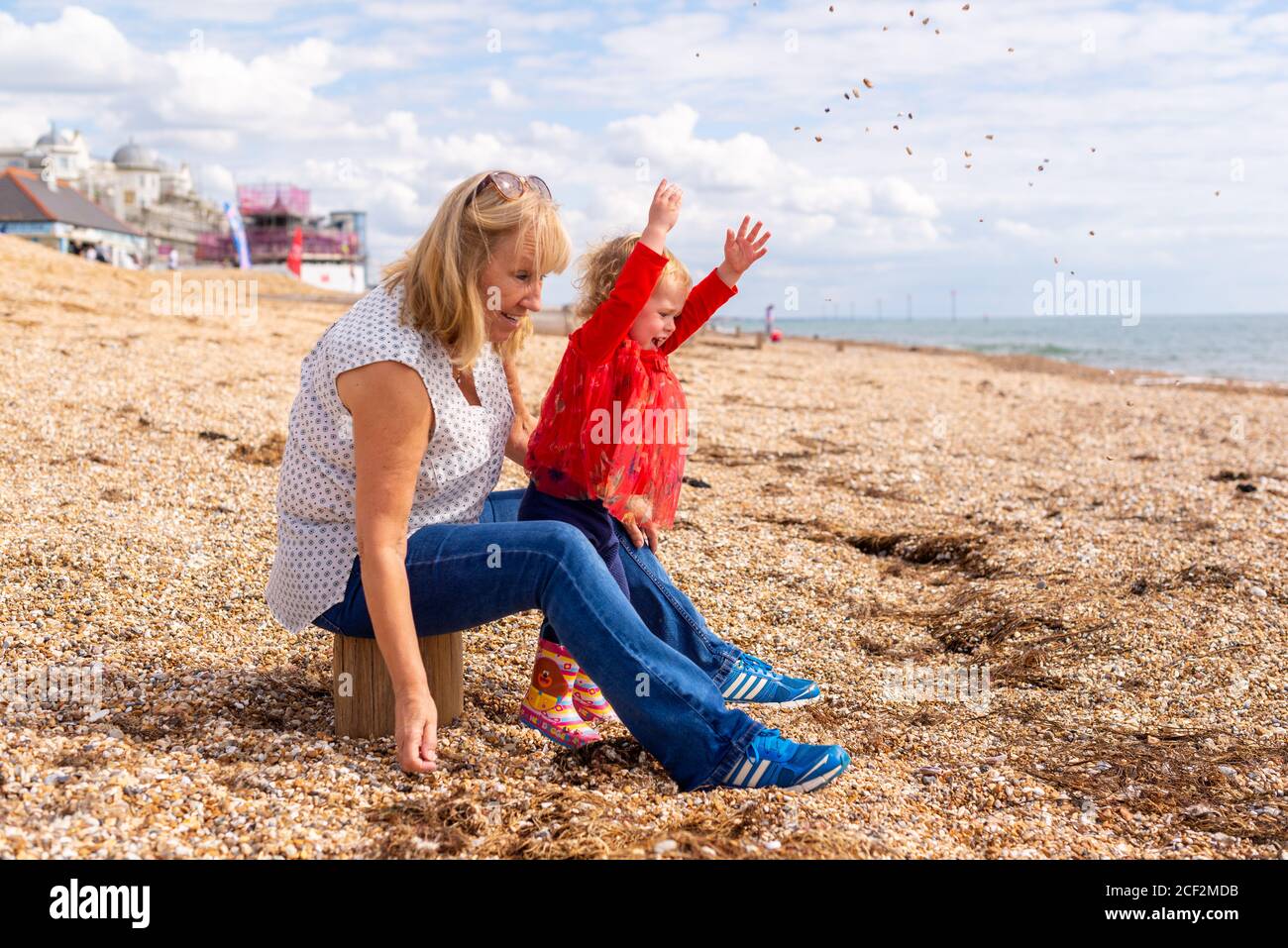 Nonno e nipote felici su una spiaggia di ciottoli in caldo sole Foto Stock