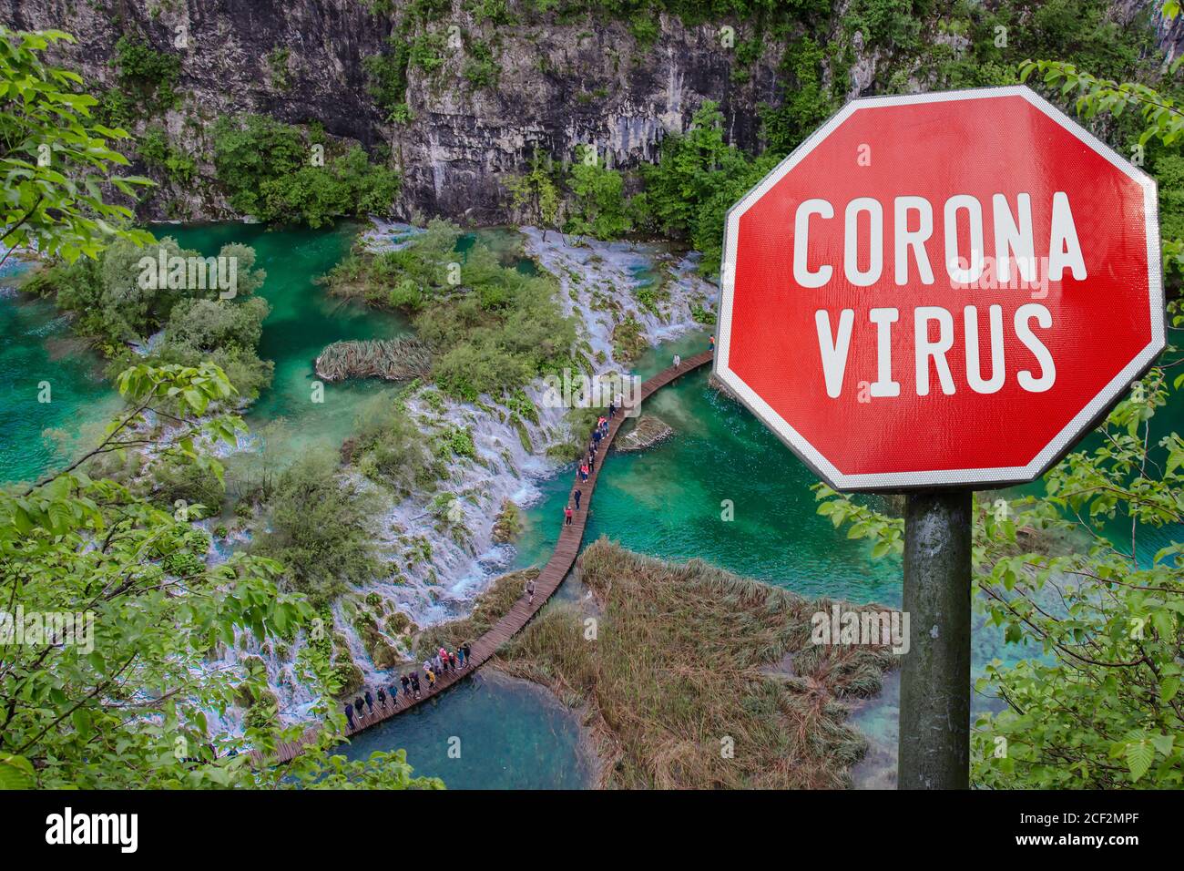Virus corona segno contro la vista dall'alto della cascata con acqua turchese nel Parco Nazionale dei Laghi di Plitvice, Croazia. Malattia del coronavirus. COV Foto Stock