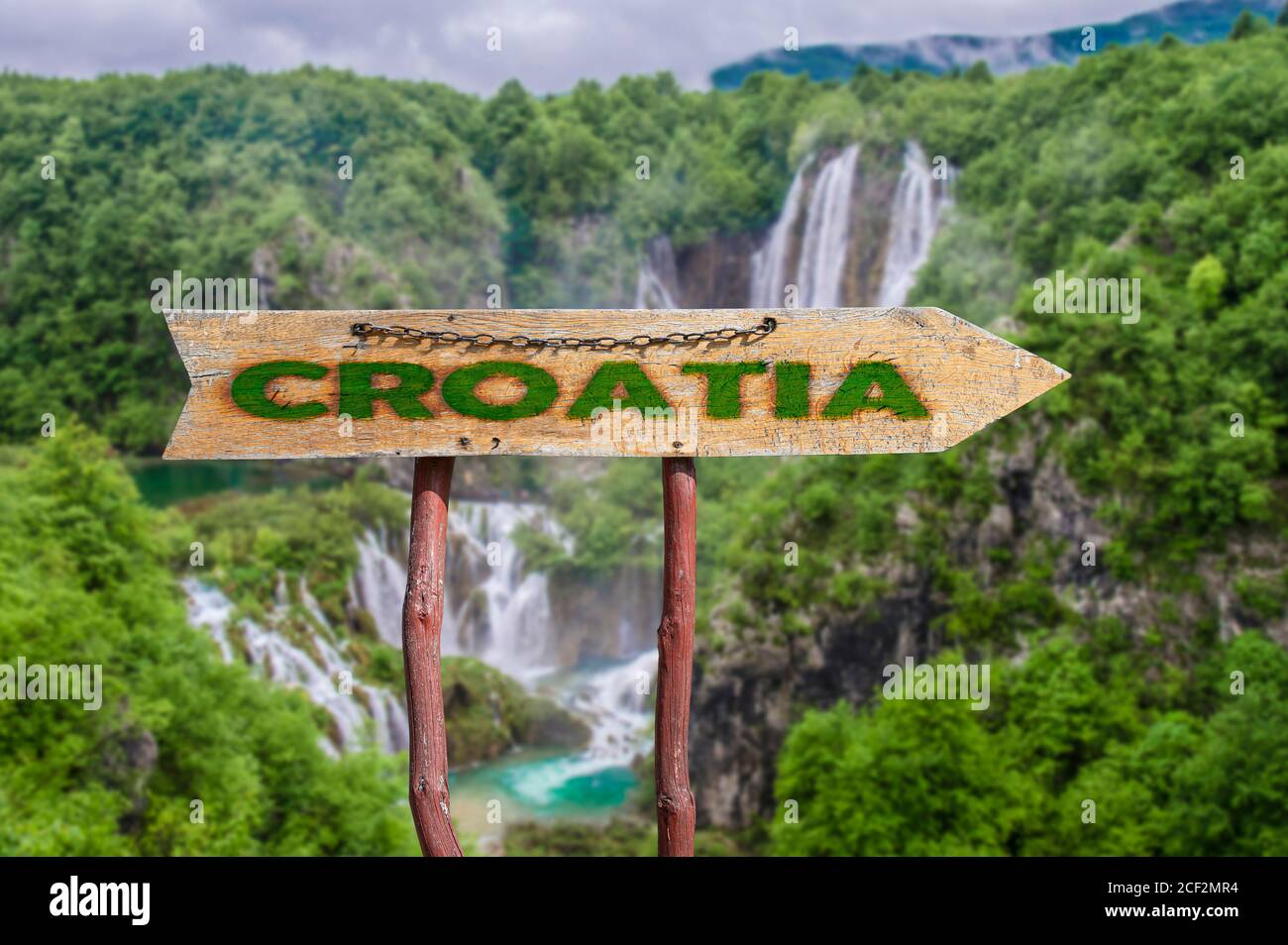 Cartello stradale freccia in legno con parola Croazia contro cascata e sfondo della foresta. Viaggio in Croazia concetto. Foto Stock