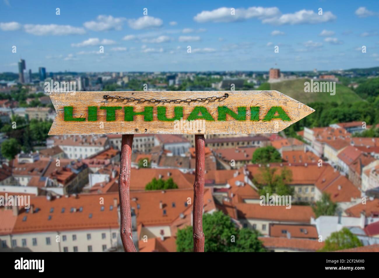 Freccia di legno con la parola Lituania contro Vilnius vecchia città di sfondo. Viaggio in Lituania Concept. Foto Stock