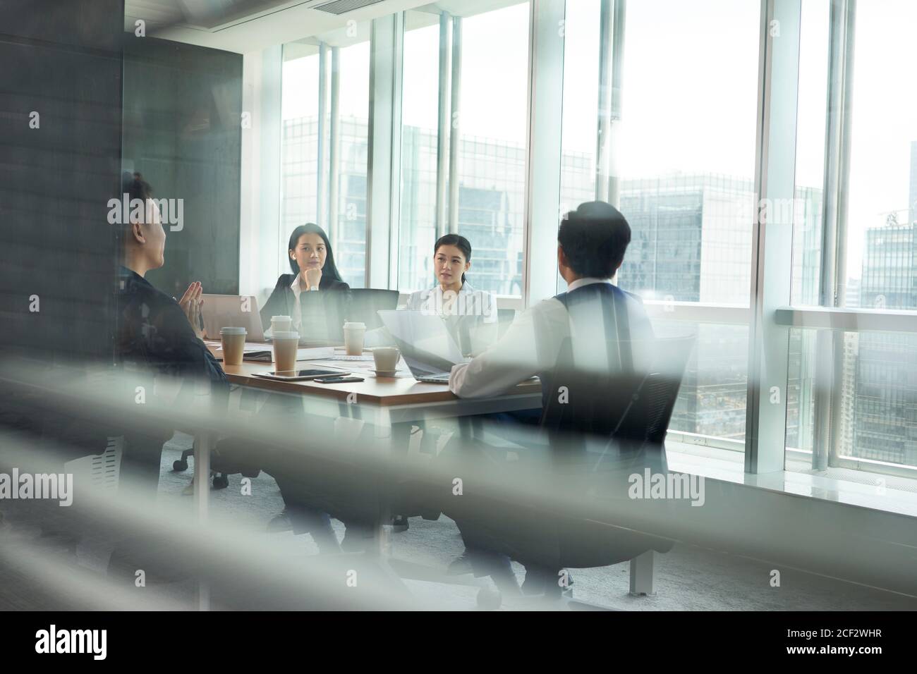 gruppo di dirigenti aziendali asiatici che si riunano nella sala conferenze in ufficio Foto Stock