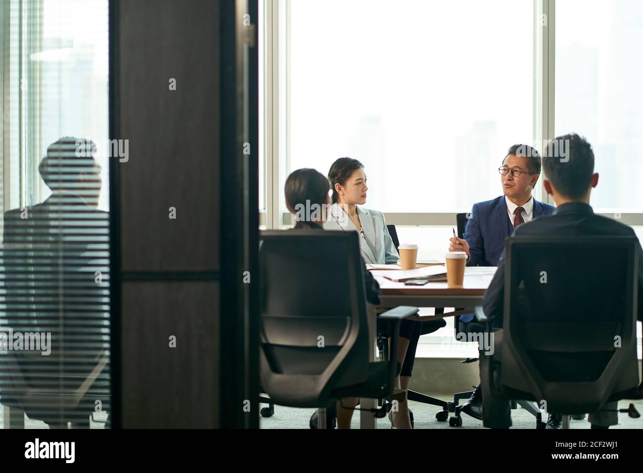 il team di dirigenti aziendali asiatici si riunisce nella sala conferenze ufficio Foto Stock