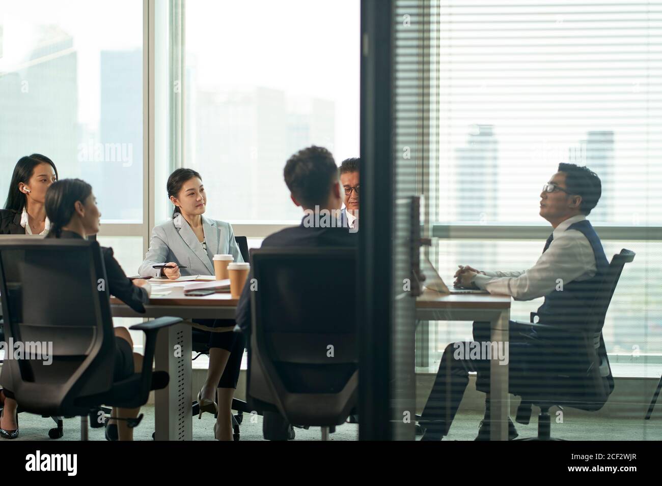 gruppo di dirigenti aziendali asiatici che si riunano nella sala conferenze in ufficio Foto Stock