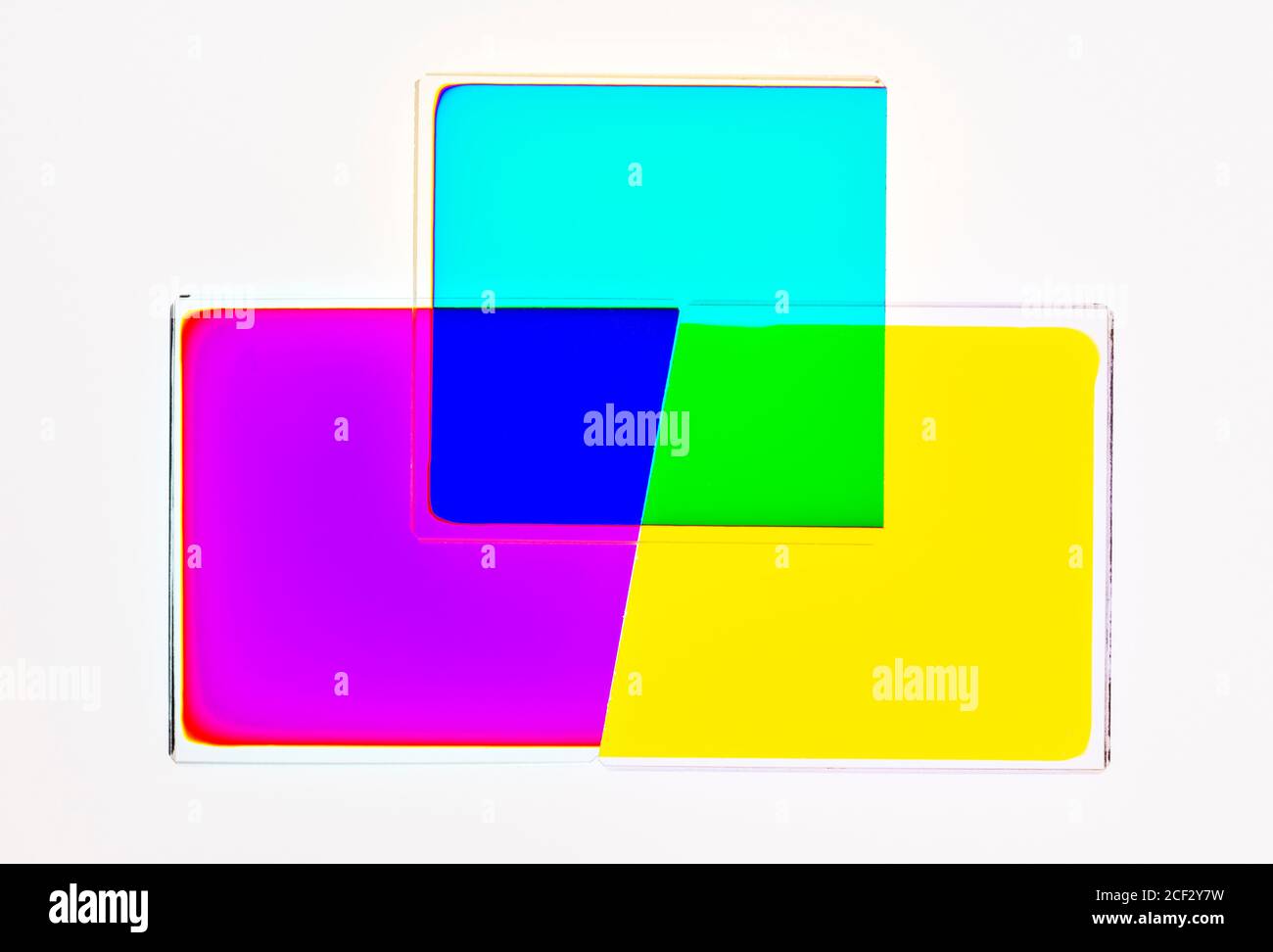 Filtri dicroici da una testina fotografica a colori ingrandenti, che mostrano l'effetto della combinazione di filtri giallo-ciano (=verde) e magenta-ciano (=blu) Foto Stock