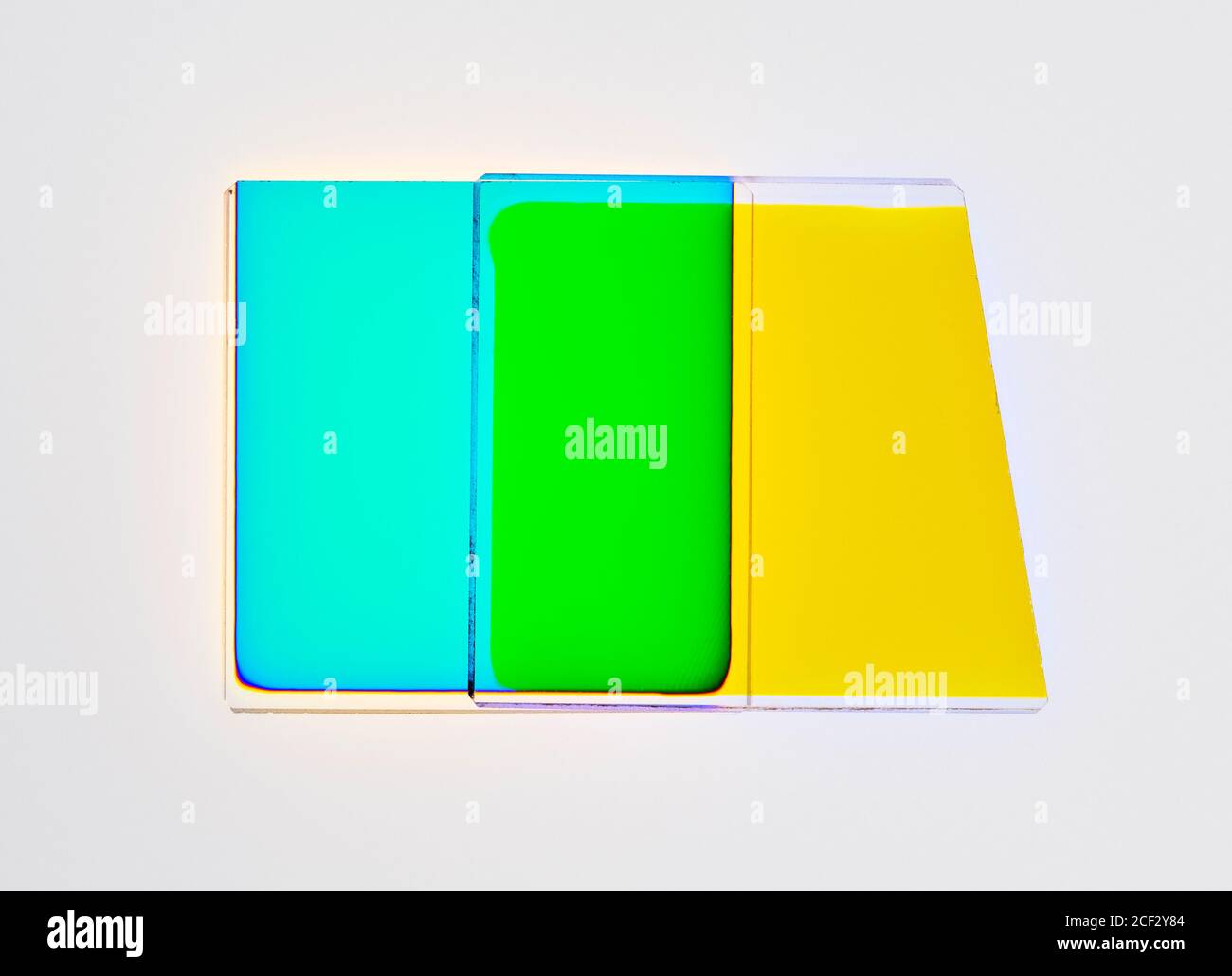 Filtri dicroici di una testina fotografica a colori ingrandente, che mostrano l'effetto di combinare i filtri giallo e ciano, producendo il verde. Foto Stock