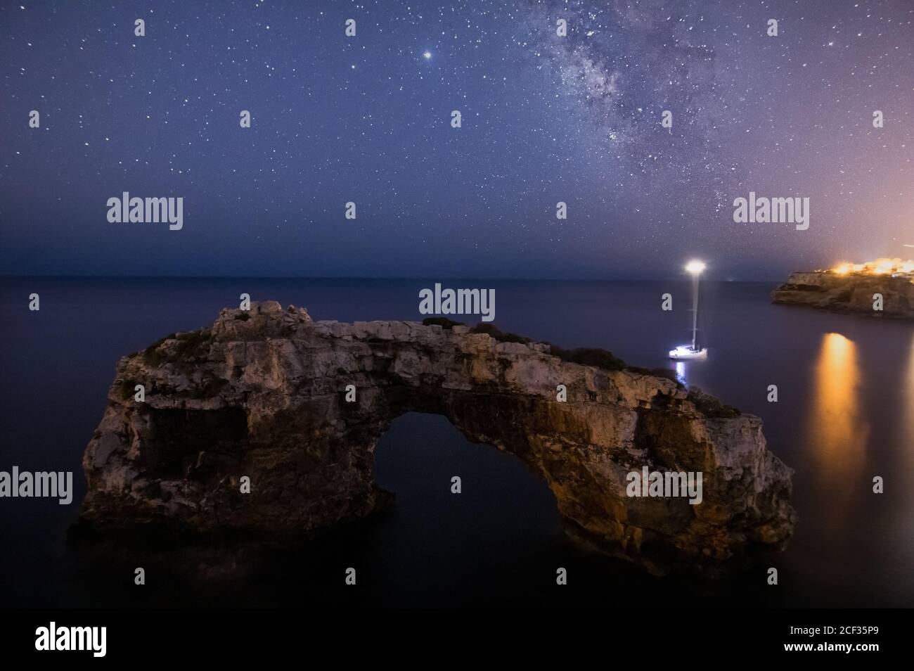 Panorama di arco di pietra e una barca a vela con la strada lattiginosa di Maiorca. Concetto di paesaggio notturno Foto Stock