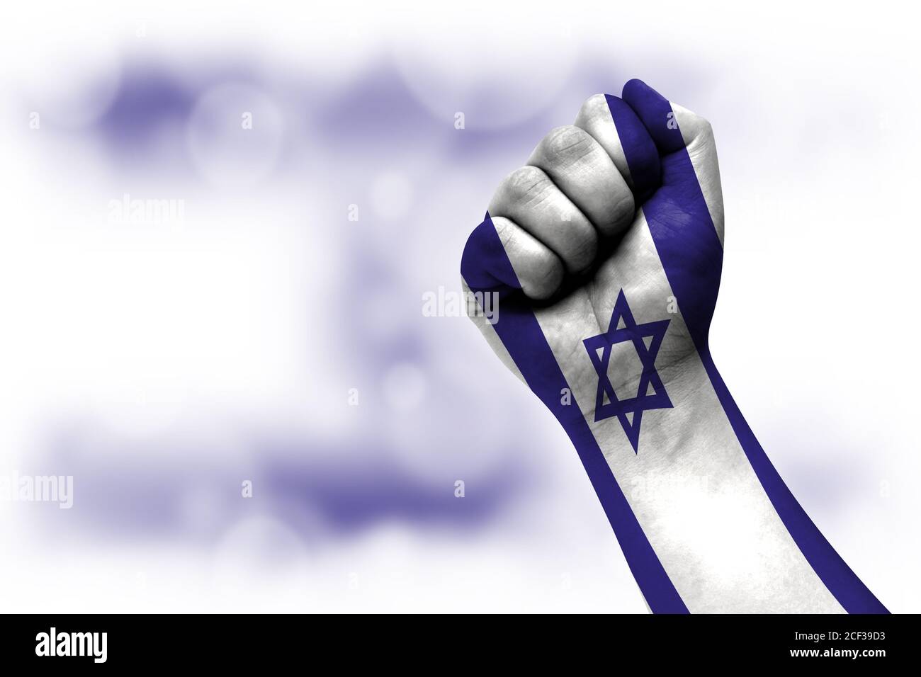 Bandiera di Israele dipinta su pugno maschile, forza, potere, concetto di conflitto. Su uno sfondo sfocato. Foto Stock